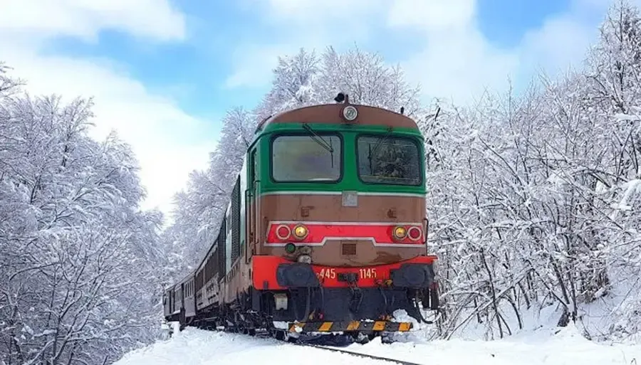 Treno storico della Transiberiana d'Italia sul paesaggio innevato dell'Appennino