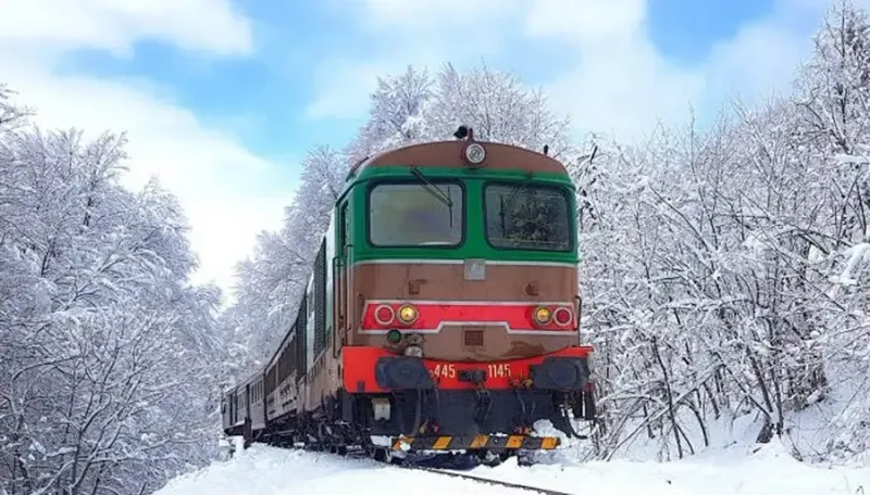 Treno storico della Transiberiana d'Italia sul paesaggio innevato dell'Appennino